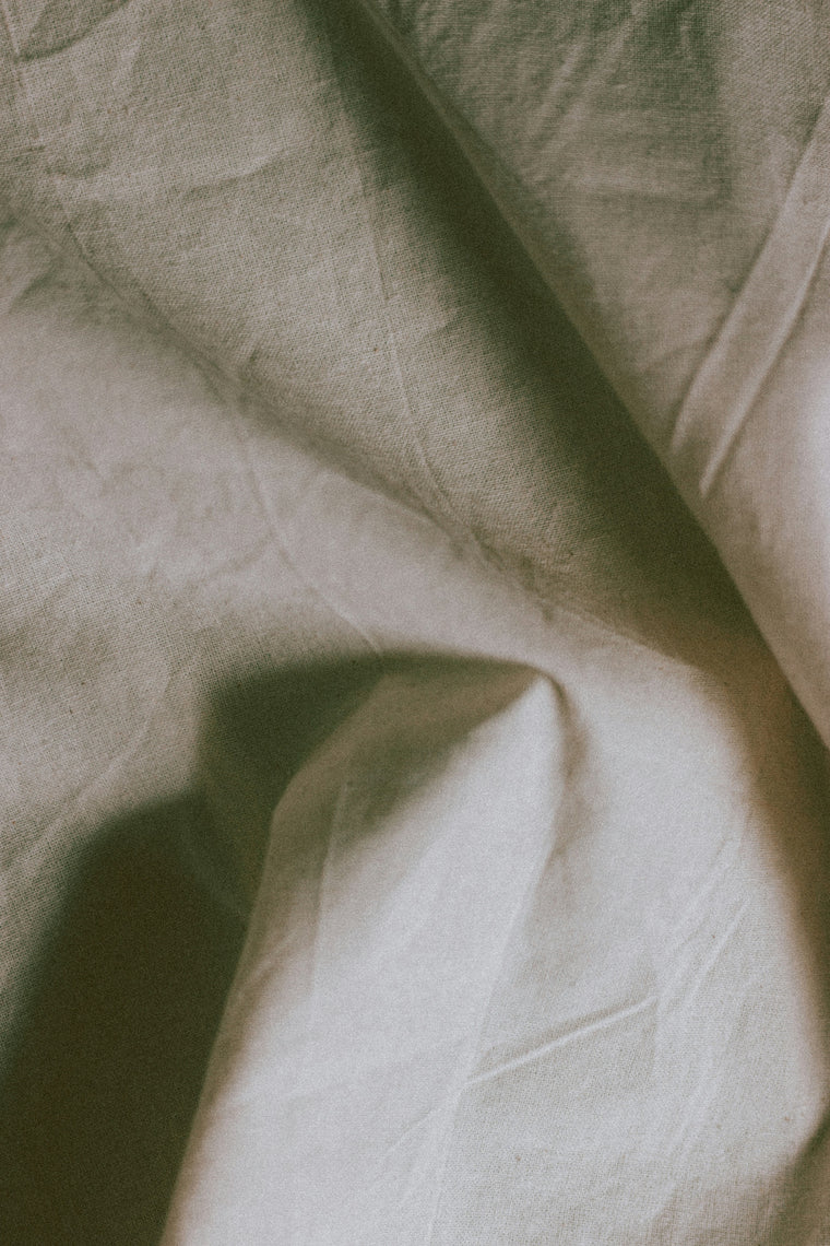 A made bed in linen, seen from above.